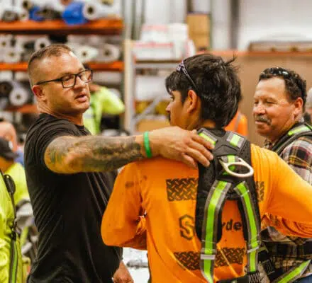 Safety Manager checks harness for fit during safety training at Snyder